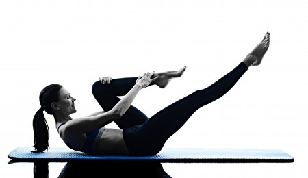 one caucasian woman exercising pilates exercises fitness in silhouette isolated on white backgound